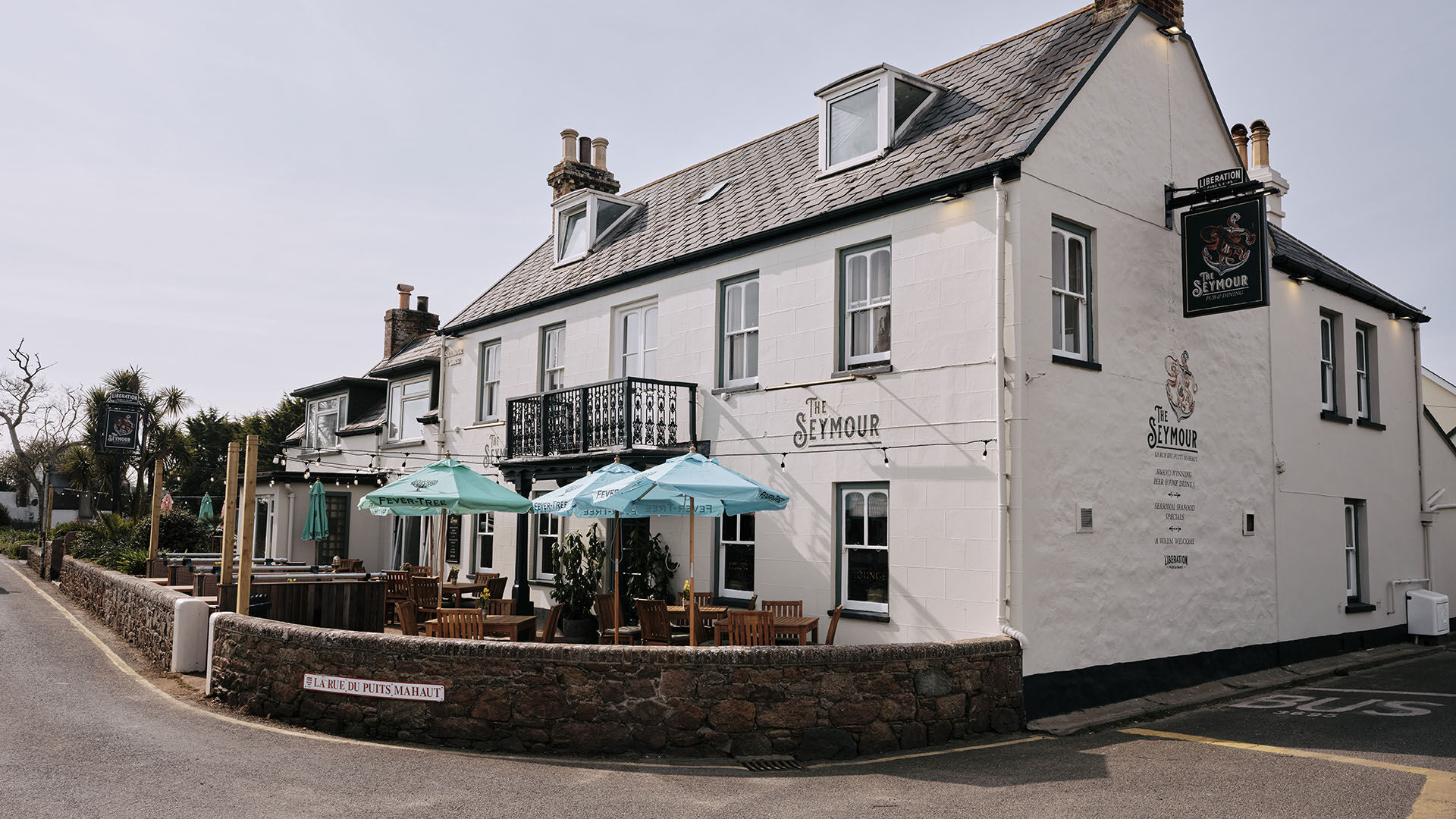 white pub with blue parasols 