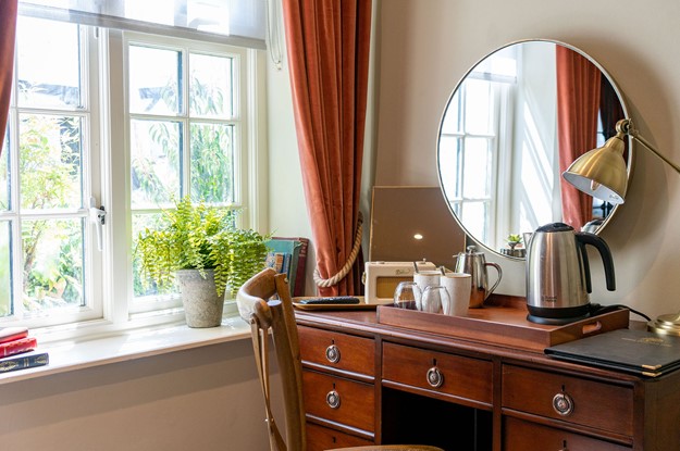bedroom desk with mirror and kettle