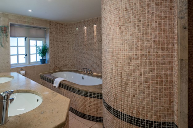 ensuite bathroom with tiled walls and bath 