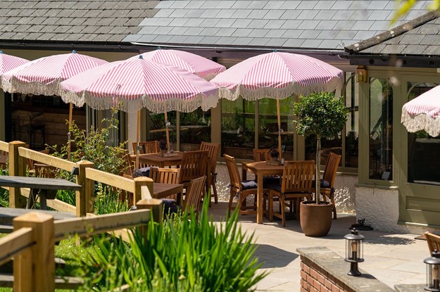 outdoor dining area with stiped pink parasols 