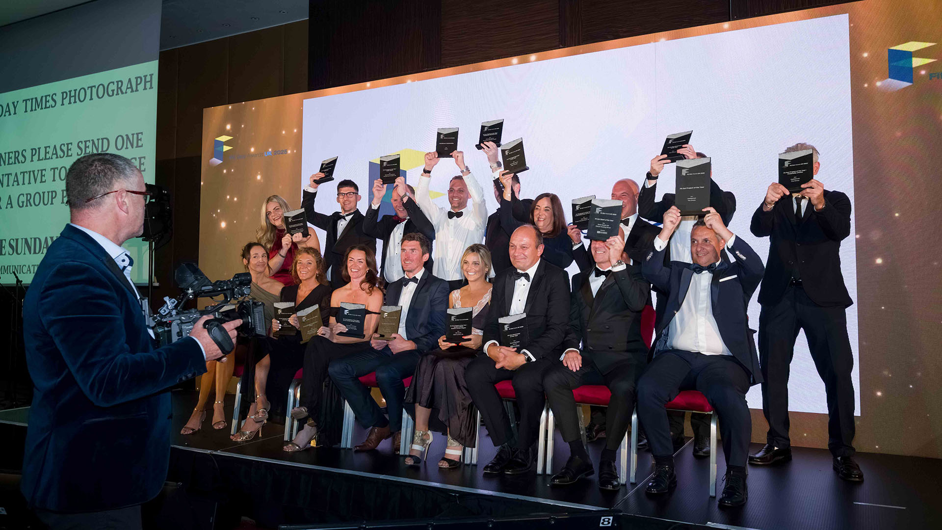 Full winners photo with all winners holding their trophies and Richard Wilson central