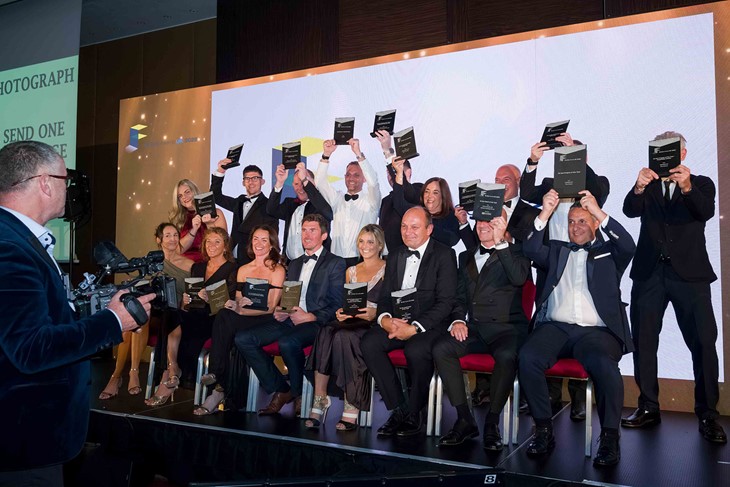 Full winners photo with all winners holding their trophies and Richard Wilson central