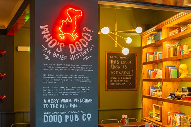 dodo neon sign pub seating area with book shelf